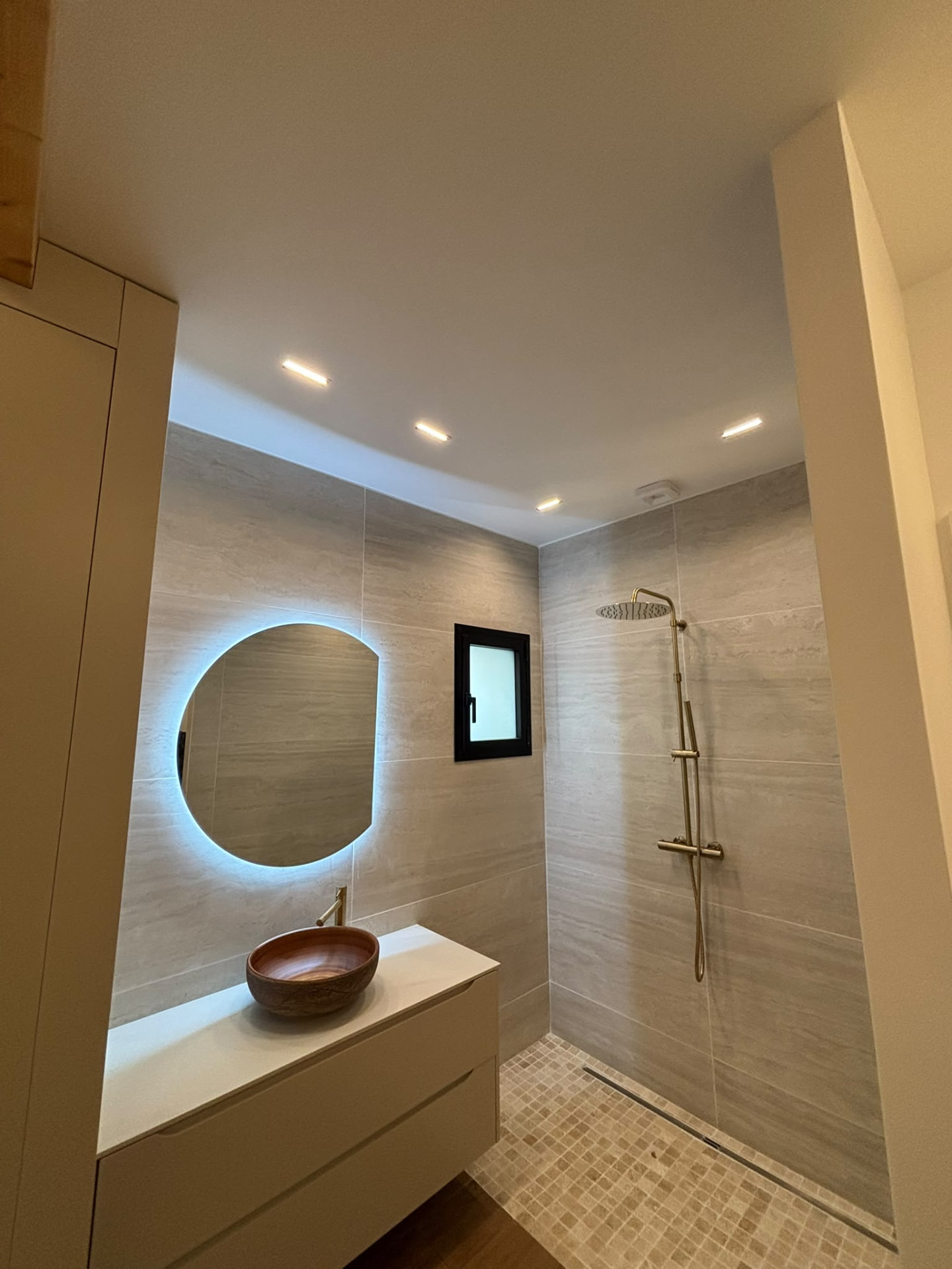 Salle de bains avec douche et miroir rétroéclairé